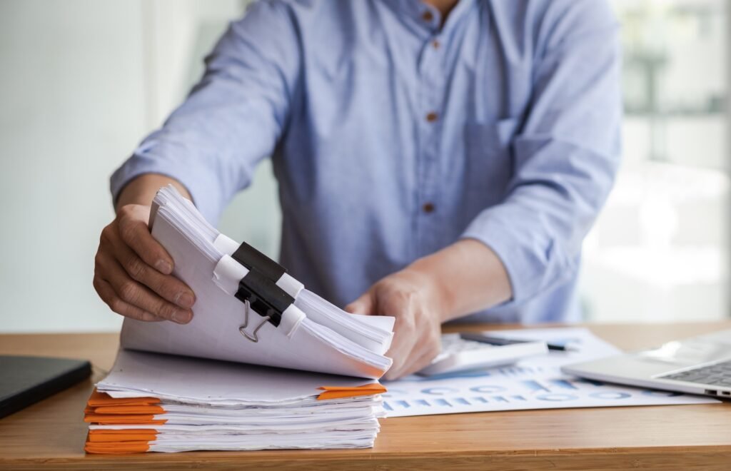 Business Documents, Auditor businessman checking working in stack of paper files.