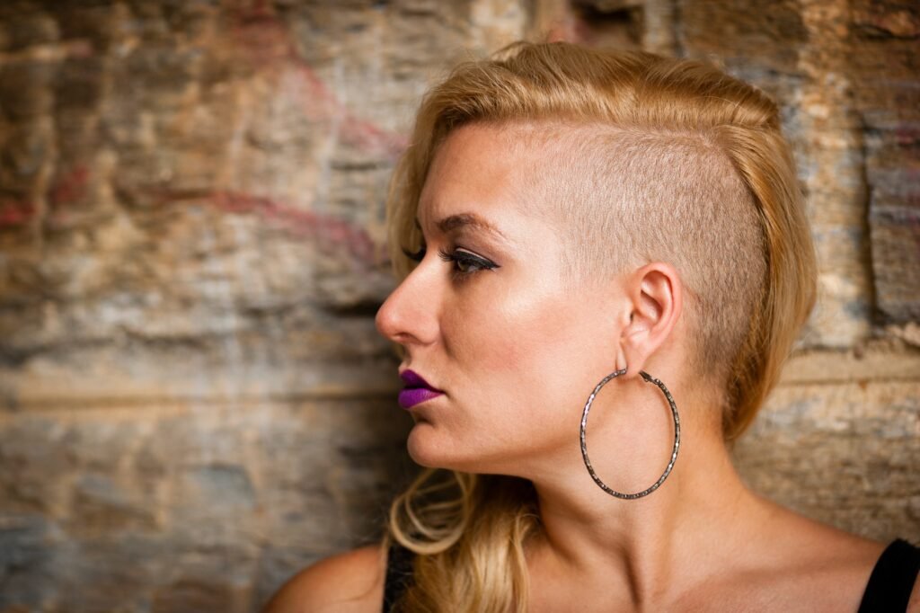 Portrait of mid adult woman with shaved blond hair looking sideways